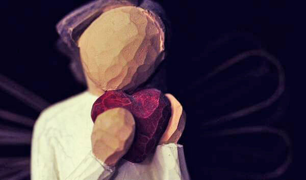 Mujer con un corazón en la mano llorando la ruptura de pareja