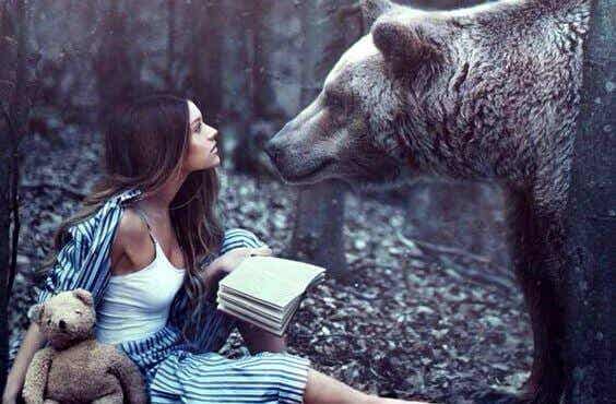Glücklichsein: Frau mit Buch trifft einen Bären