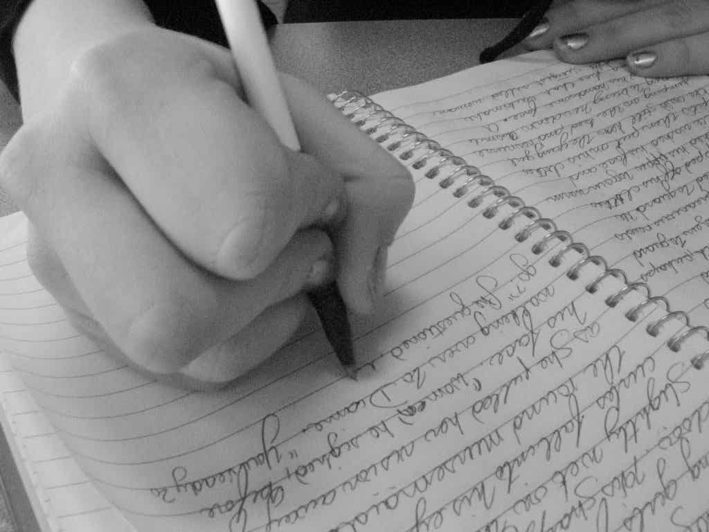 Mujer escribiendo para un estudio de grafología