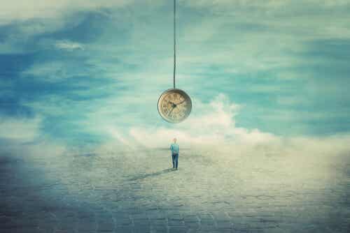 Hombre bajo reloj simbolizando la procrastinación y su relación con la ansiedad 