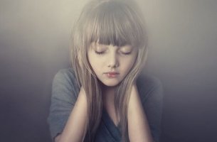 Niña en silencio tapándose los oídos