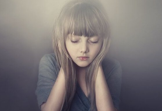 Niña en silencio tapándose los oídos