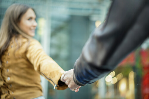 Pareja agarrada de la mano paseando