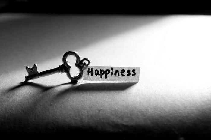 Llave con una hoja escrita con la palabra felicidad en inglés