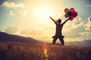 Mujer con globos saltando pensando en atreverse a hacer realidad sus sueños