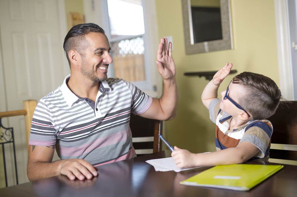 Padre ayudando a su hijo a hacer los deberes