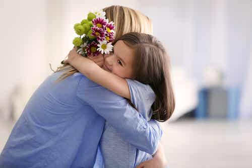 Madre e hija abrazadas con flores