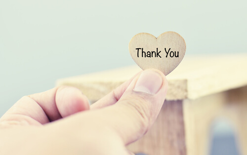 Mano sujetando un corazón con dos palabras en inglés