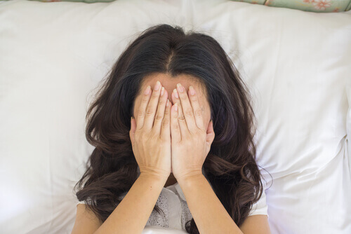 Mujer tapándose la cara preocupada