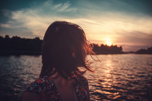 Mujer mirando hacia el mar dando las gracias