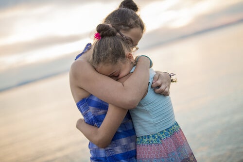 Hermanas abrazándose en la playa