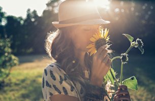Mujer oliendo un girasol