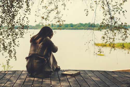 Mujer triste pensando en los cambios de su vida en el lago