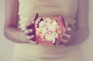Manos de chica con mariposas y luces para embellecer momentos