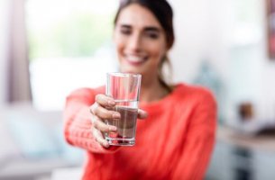 Mujer enseñando un vaso medio lleno