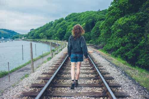 Mujer caminando por la vía del tren