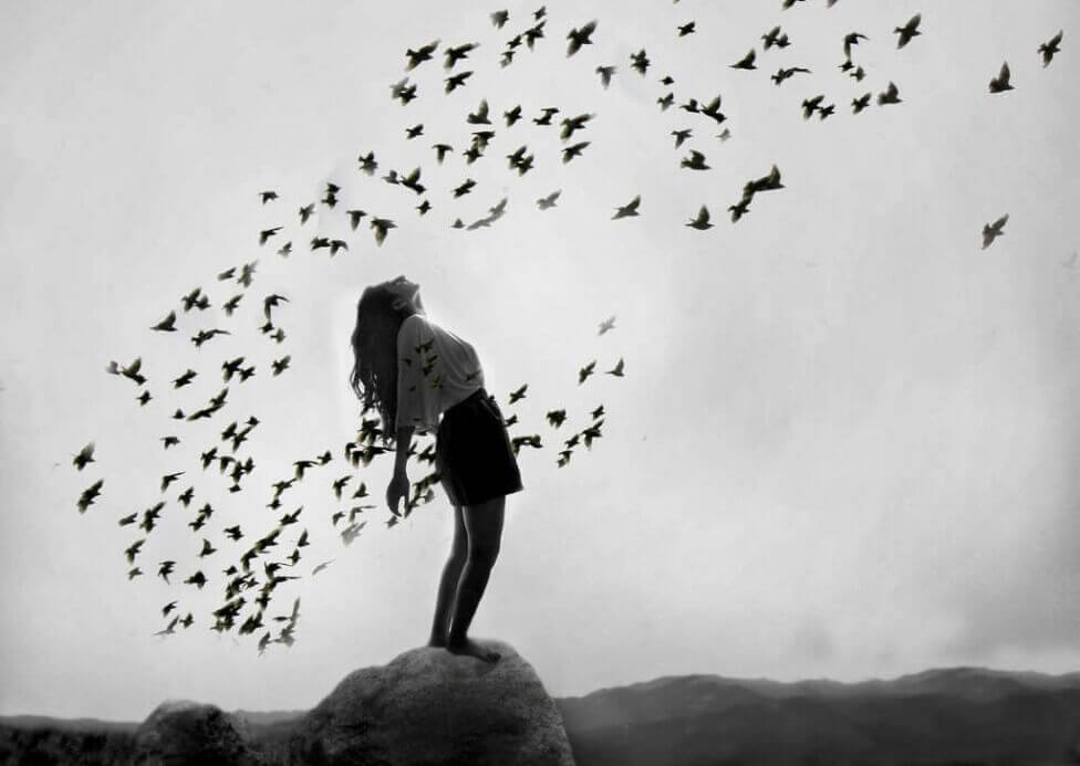Mujer rodeada de pájaros