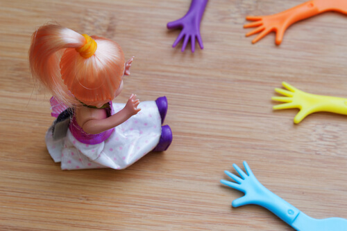 Muñeca con manos de juguete alrededor