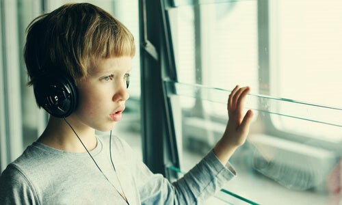 Niño con trastorno del espectro autista mirando por la ventana