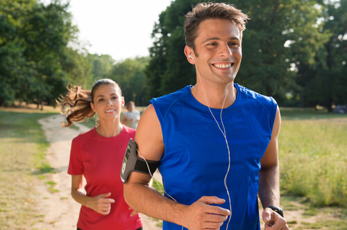 Pareja corriendo feliz por el campo por la psicología deportiva
