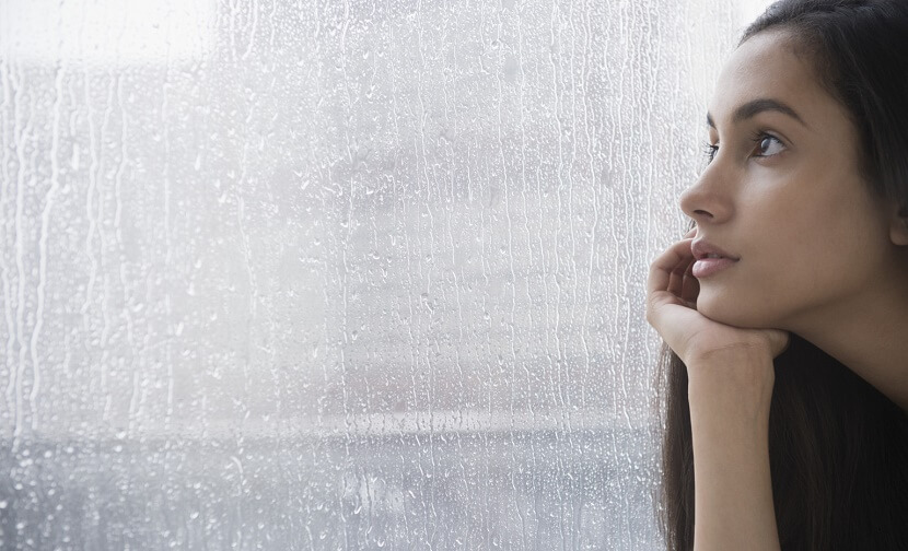 adolescente triste apoyando la cabeza en su mano