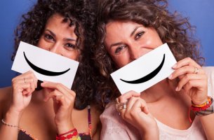 Amigas sujetando un cartel con una sonrisa