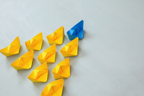 Barcos de papel amarillos siguiendo a un barco de papel azul