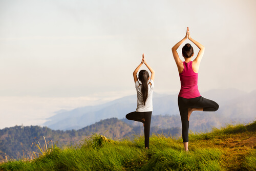 Hija haciendo yoga con su madre a través del aprendizaje vicario