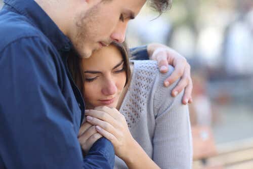 Hombre abrazando a su pareja mientras siente dolor