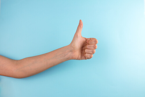 Mano con el pulgar levantado como ejemplo de gestos