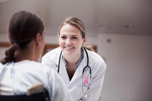 Médico con con mujer hablando sobre Sobrevivir al cáncer