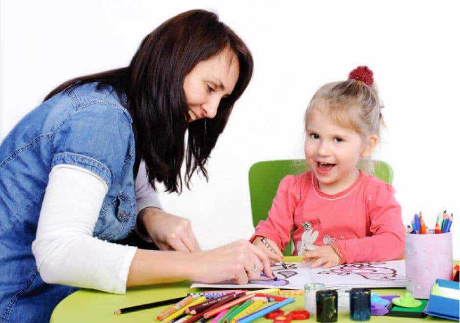 Mujer coloreando con una niña