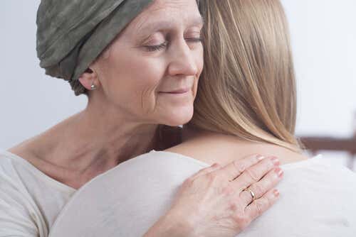 Mujer con cáncer de mama abrazando a su hija sufriendo el efecto del quimiocerebro