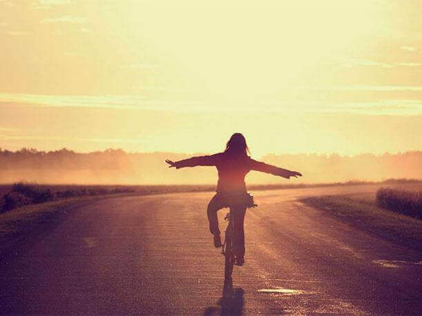 Mujer disfrutando de su felicidad en bicicleta