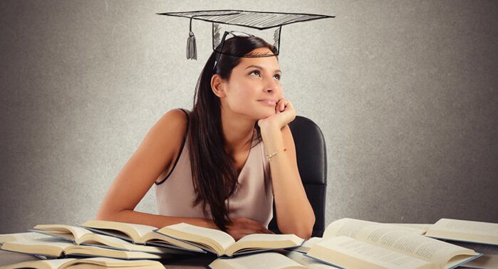 Mujer estudiando con muchos libros