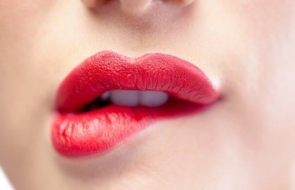 mujer que se muerte el labio en gesto de inocencia