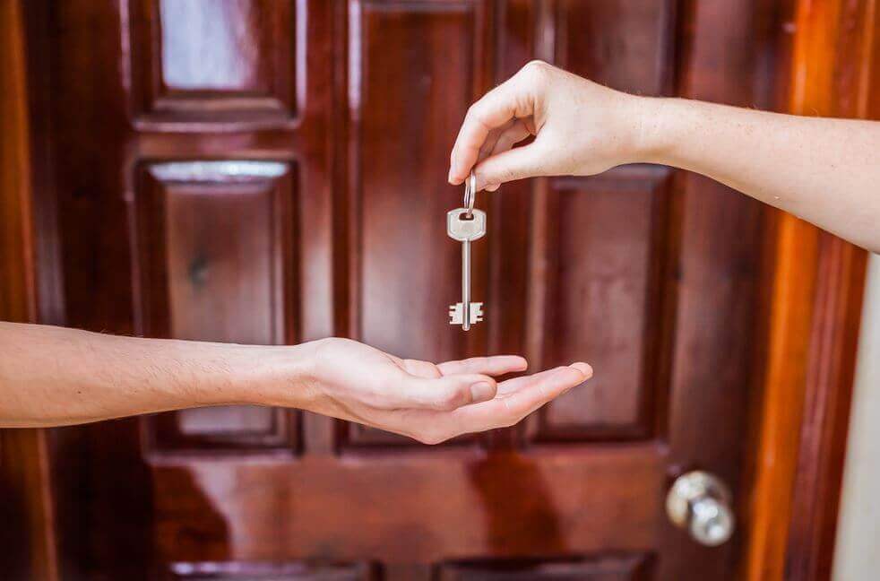 Mano dando una llave a otra