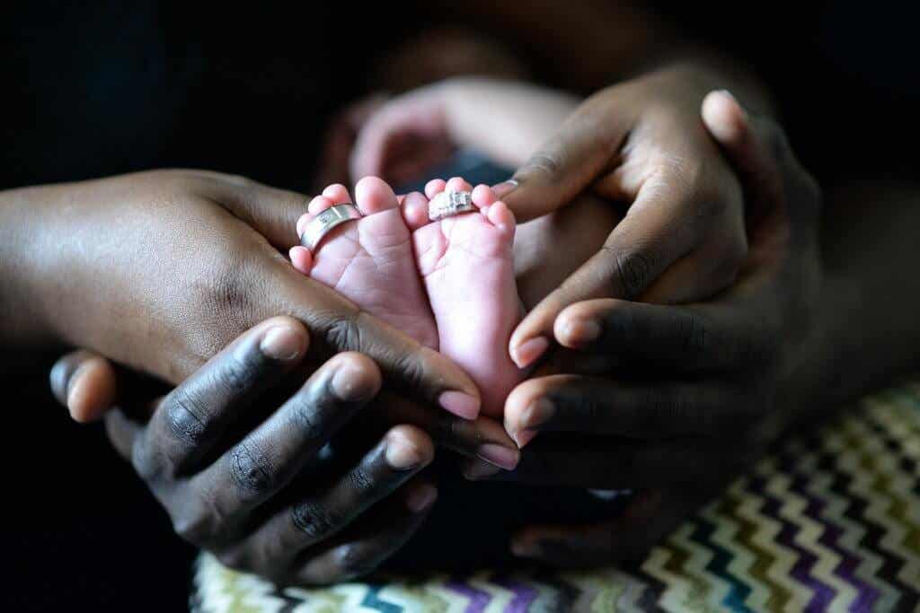Manos cogiendo pies de un bebé
