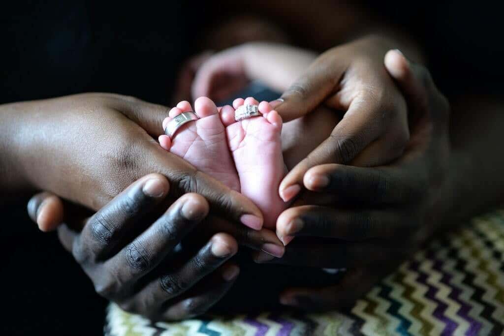 Manos cogiendo pies de un bebé