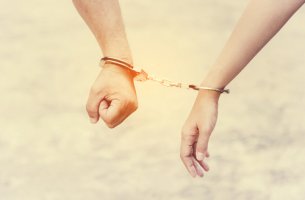 Manos de una pareja esposadas simbolizando relaciones adictivas