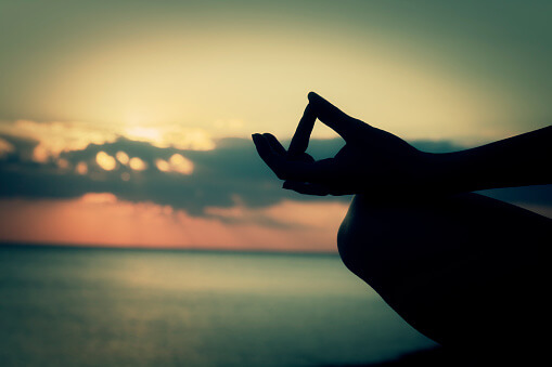 Mano de una persona en posición de meditación