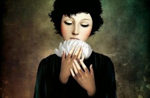 mujer con flor blanca en las manos experimentando gratitud