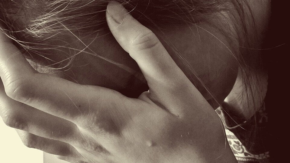 Mujer con la mano en la frente agotada
