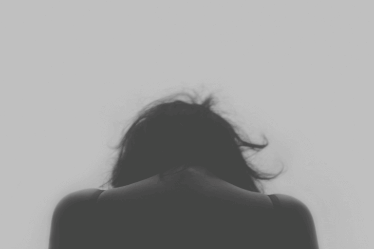 Mujer triste mirando hacia el suelo por situación de maltrato