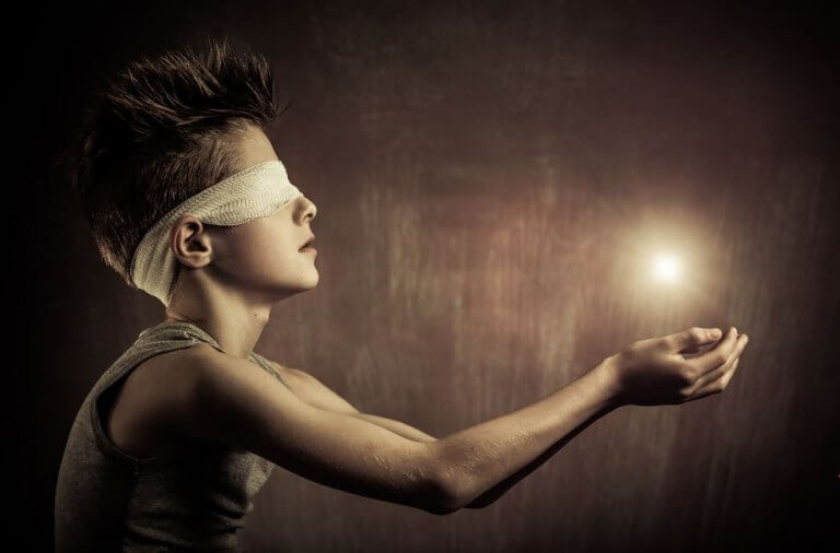 Niño con una luz sobre sus manos