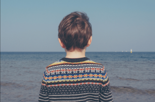 Niño de espaldas mirando al mar