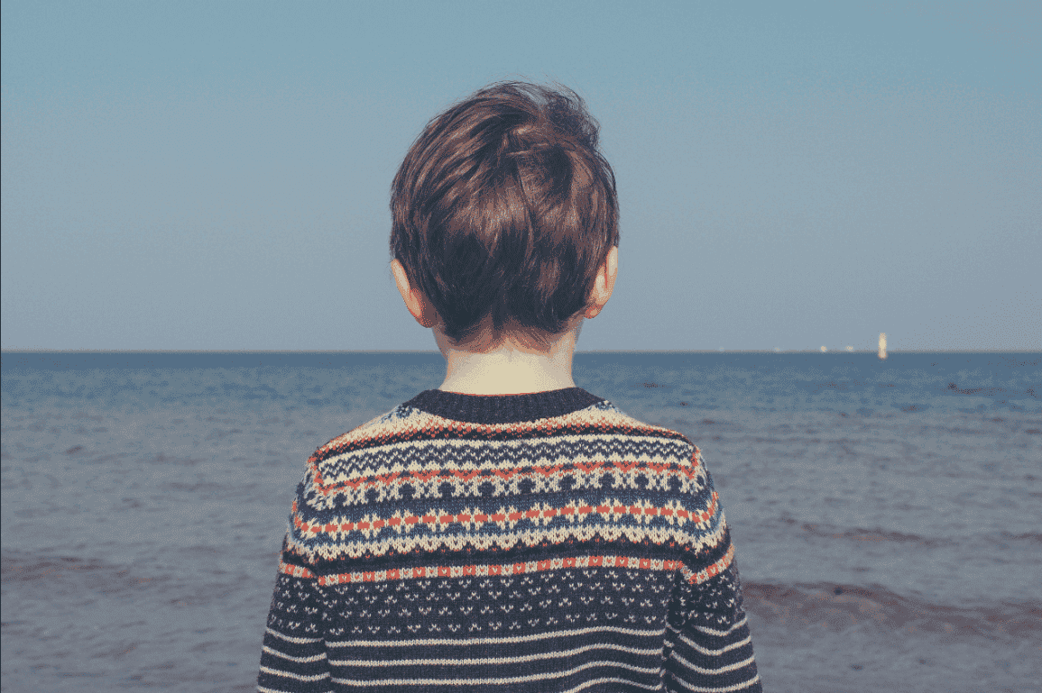 Niño de espaldas mirando al mar