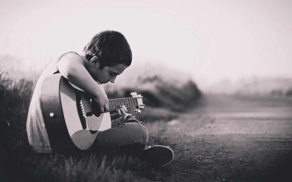 niño desanimado con guitarra