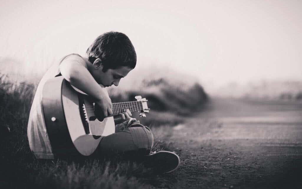 Niño triste tocando la guitarra