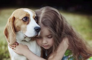 Niña abrazando a uno de sus perros